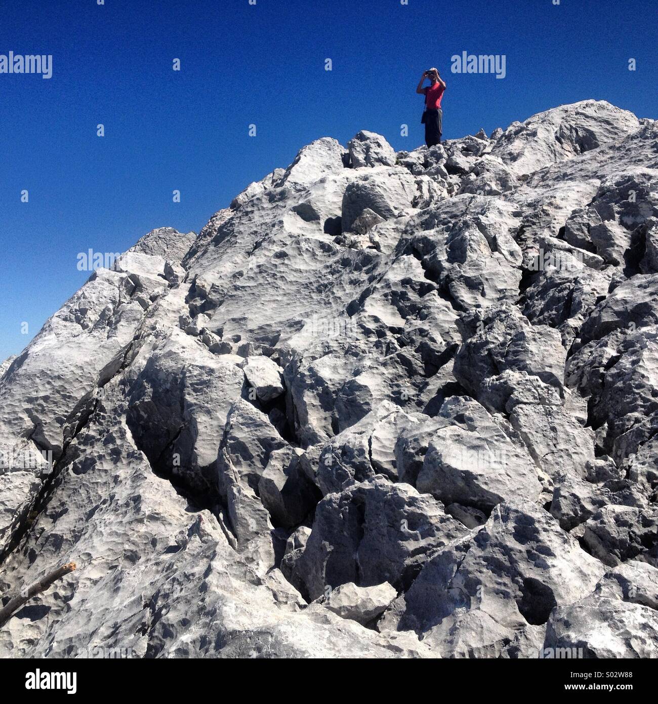 Ein Tourist nimmt Bilder auf Simancon Berggipfel in den Parque Natural Naturpark Sierra de Grazalema, Grazalema, Cadiz Provinz, Andalusien, Spanien - Smartphone-aufgenommenes Stockfoto