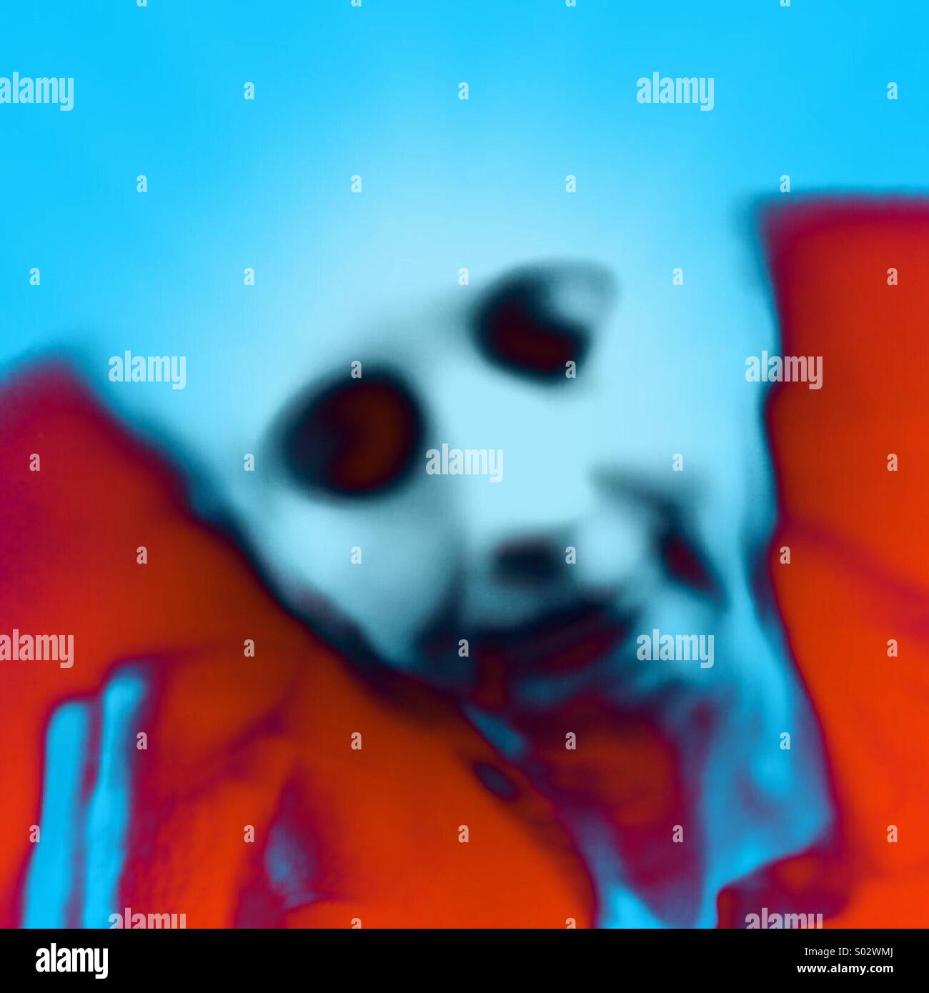 Ein geisterhaftes Gesicht mit Totenkopf-ähnliches Augenhöhlen schwimmend auf einem leuchtend rotem Grund Stockfoto