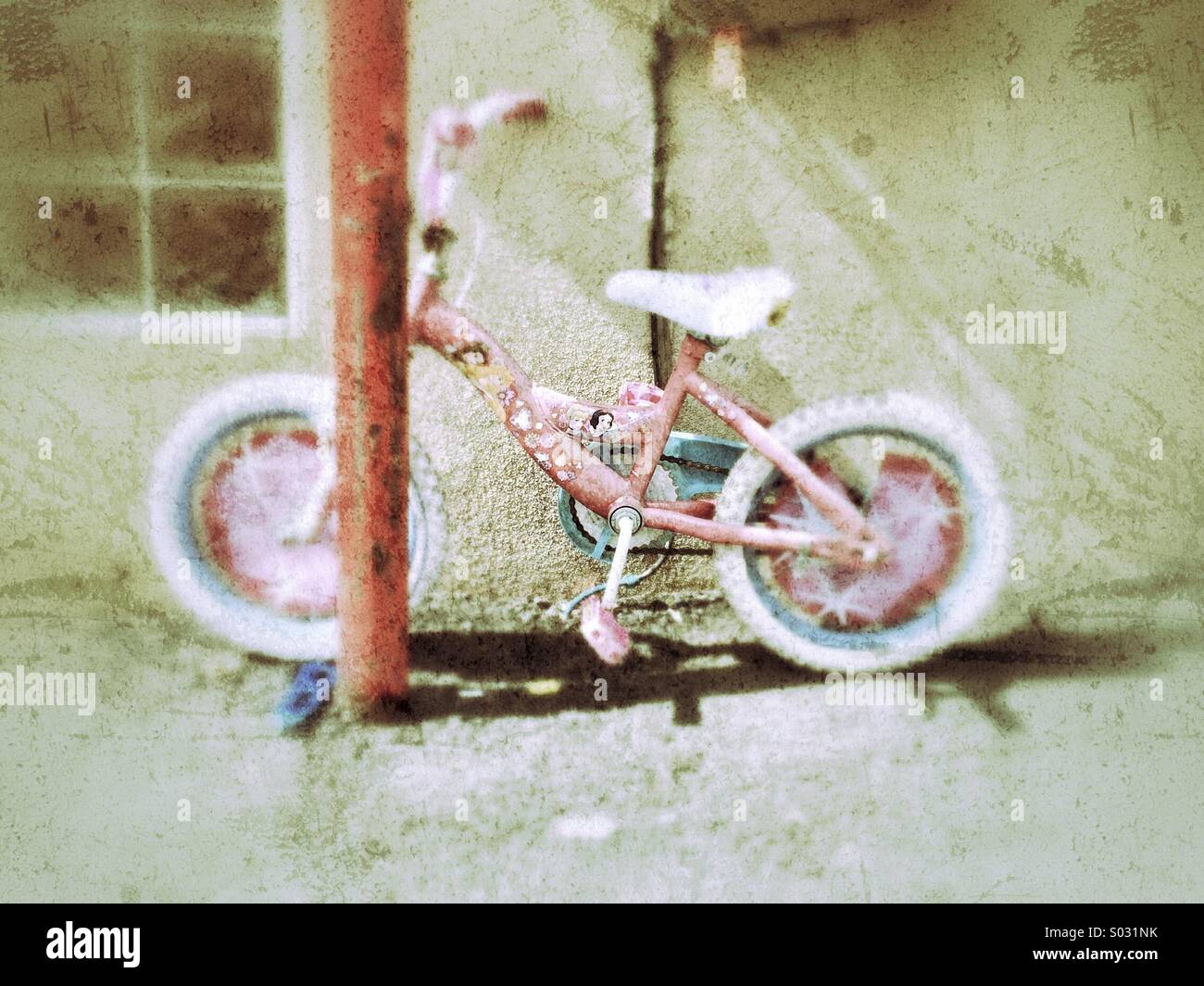 Rosa Fahrrad entlang Wand geparkt Stockfoto