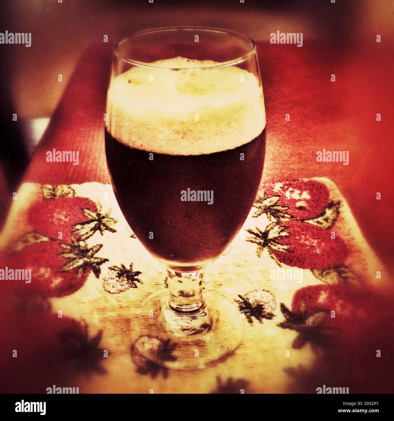 Glas Bier auf dekorativen Platzdeckchen Stockfoto
