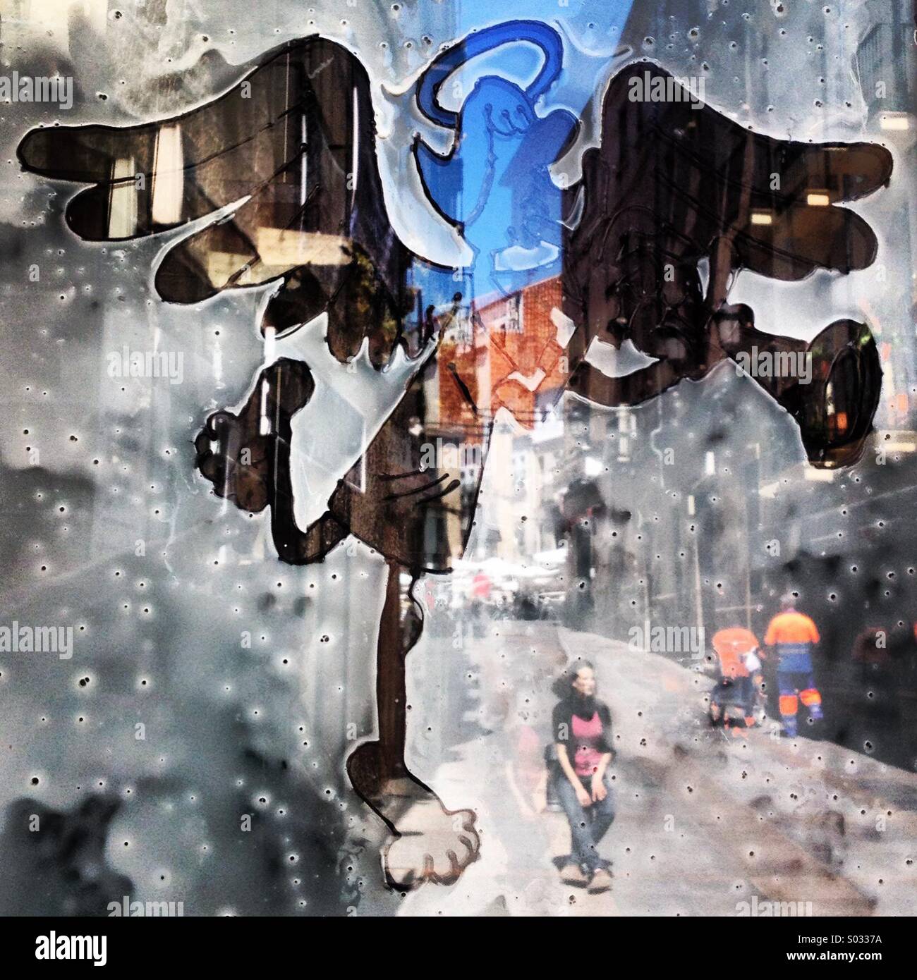 Ein Engel spielt die Trompete und die Reflexion einer Straße sind zu sehen in La Divina Comedia Bar in Cáceres, Extremadura, Spanien - Smartphone-aufgenommenes Stockfoto