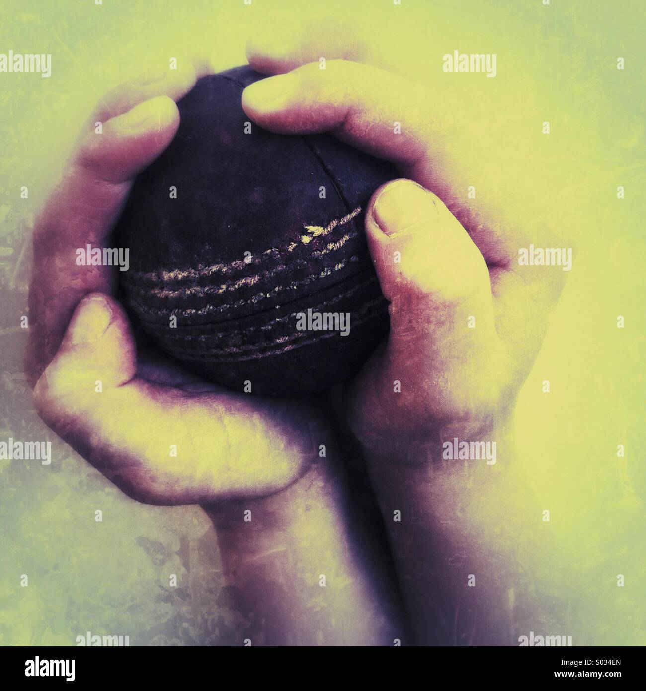 Junge umklammert ein Cricketball - Smartphone-aufgenommenes Stockfoto