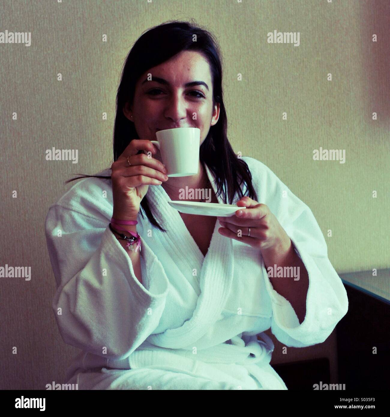 Frau trinkt Tee in einem weißen Bademantel Stockfoto