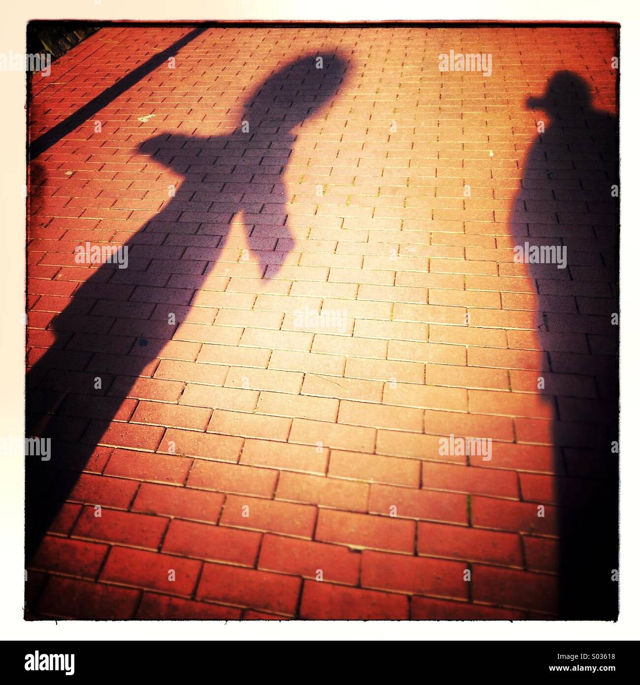 Stimmung-Schatten von zwei Personen zu Fuß auf dem Gehweg Bürgersteig Stockfoto