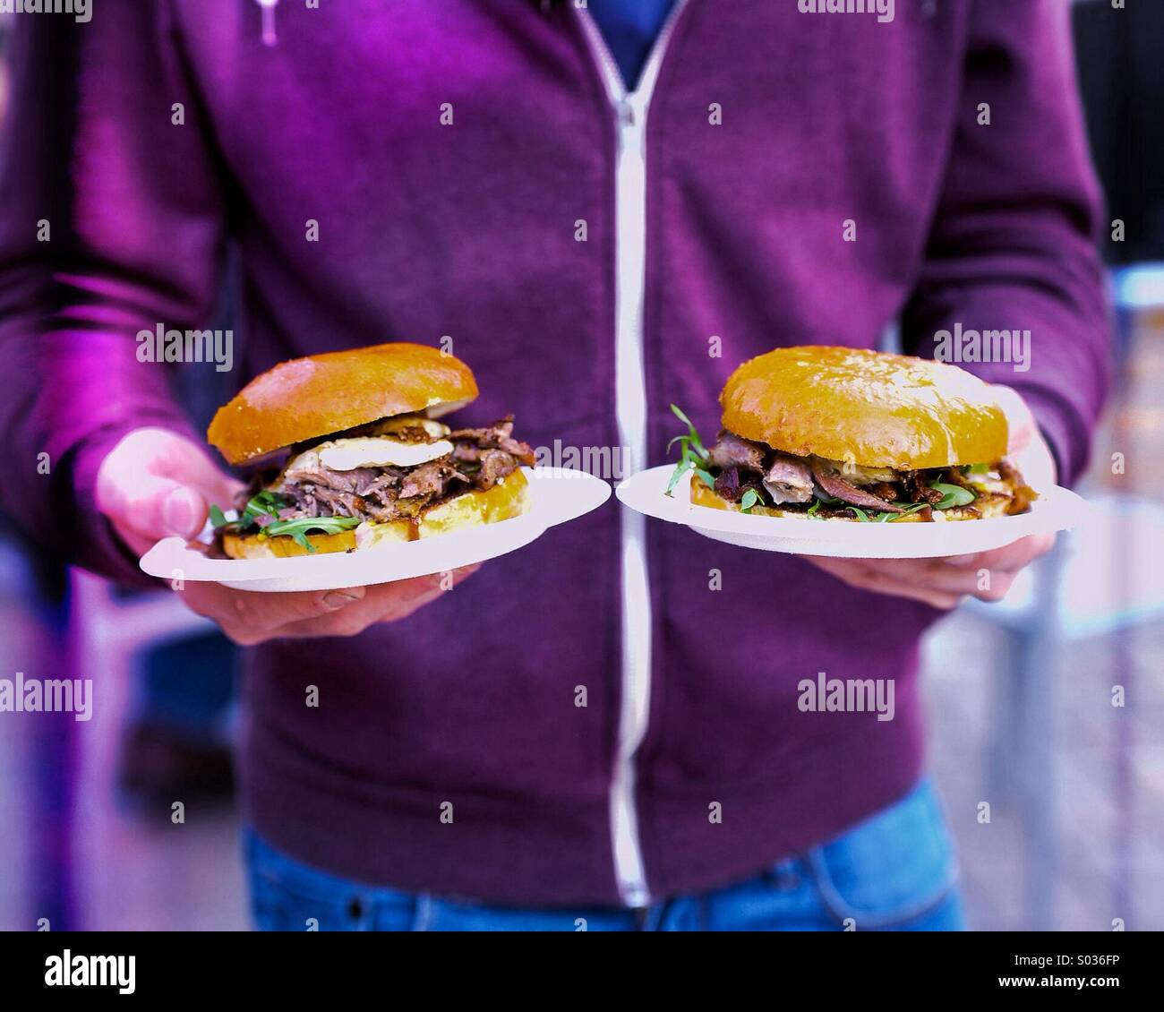 Mann halten zwei Burger Stockfoto