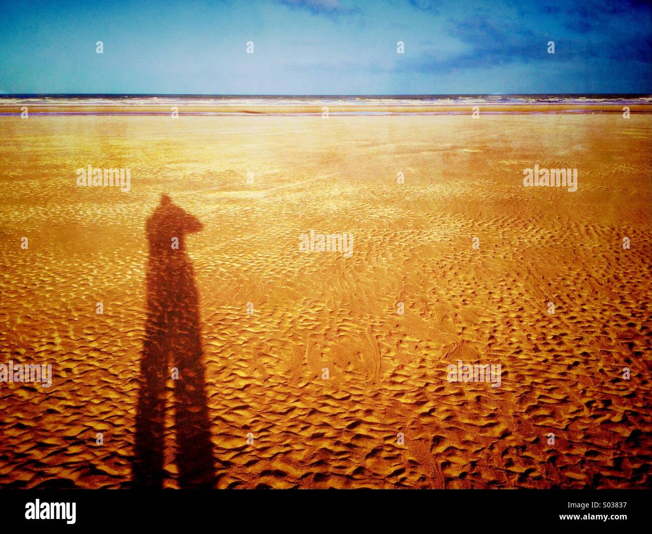 Lange Schatten der Person am Strand von Blackpool Stockfoto