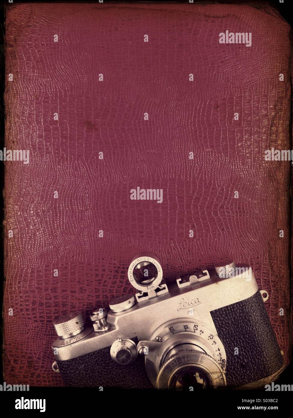 Alte Vintage-Kamera Leica ruht auf rotem Leder - Smartphone-aufgenommenes Stockfoto