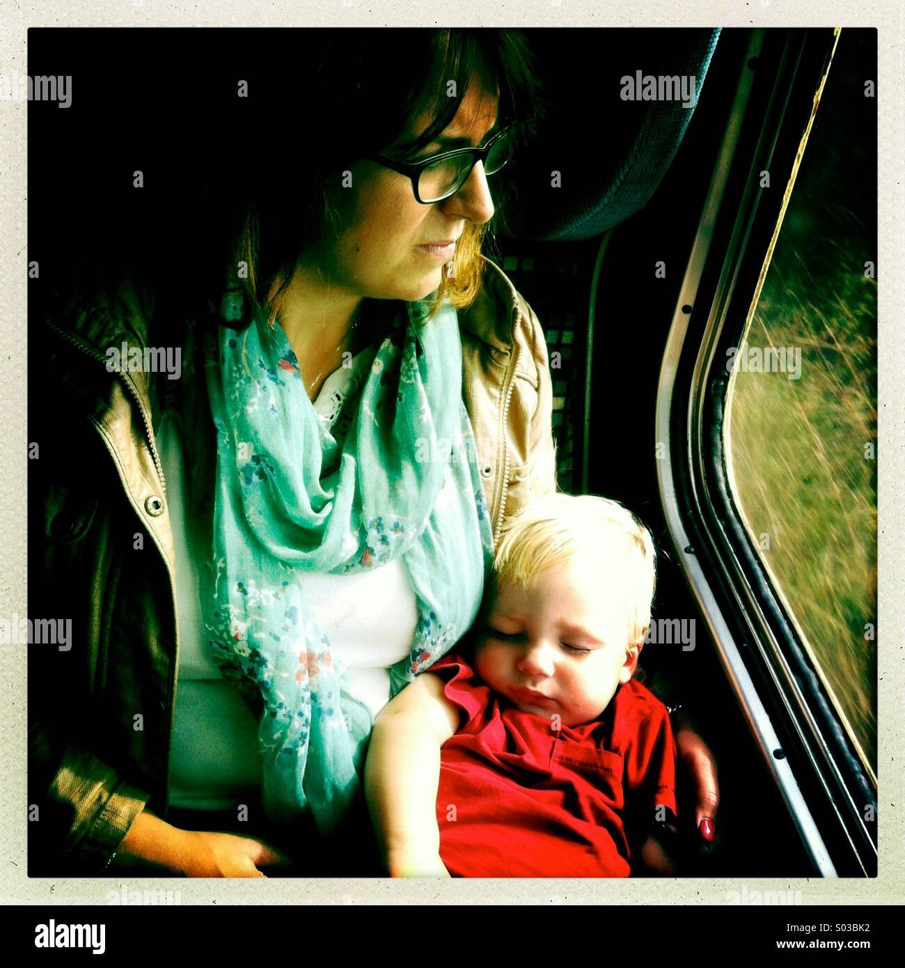 Mutter und Sohn nehmen eine Fahrt in einem Zug mit Baby ein Nickerchen Stockfoto