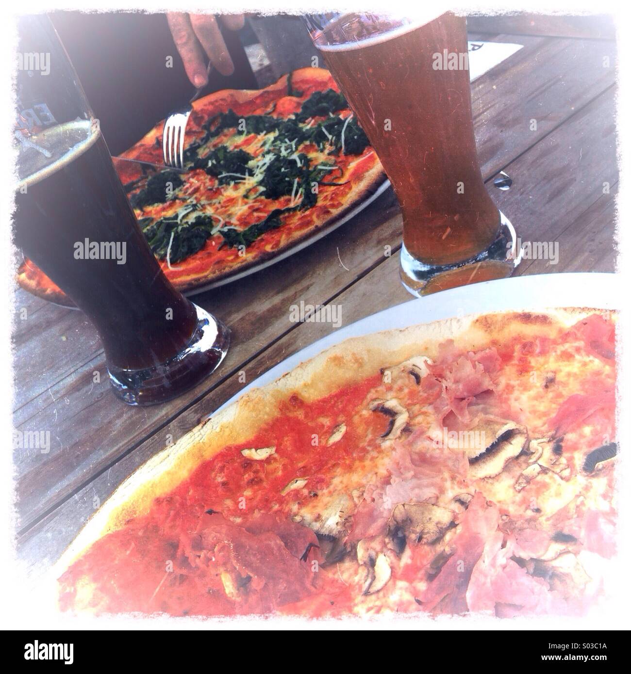 Zwei Pizzen und zwei Gläser Bier - Smartphone-aufgenommenes Stockfoto
