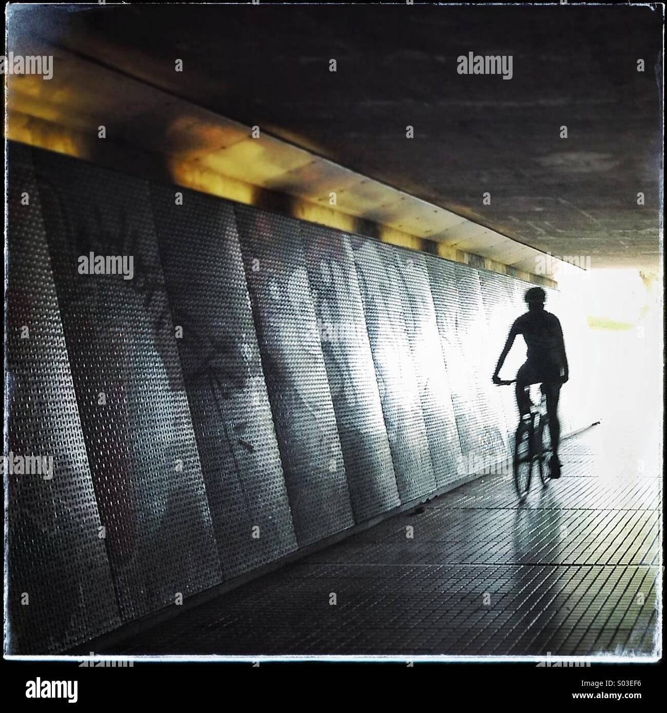 Silhouette der ein Fahrrad durch eine dunkle Unterführung symbolisiert Licht am Ende des Tunnels Stockfoto