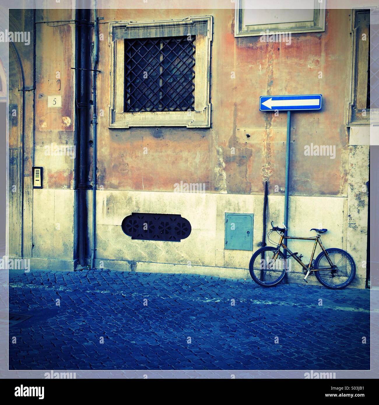 Fahrrad gegen eine Wand in einer Seitenstraße in Rom, Italien Stockfoto
