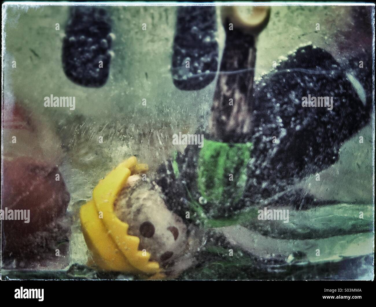 PLAYMOBIL auf Eis. Gefrorene Spielzeug in kaltem Wasser. - Smartphone-aufgenommenes Stockfoto