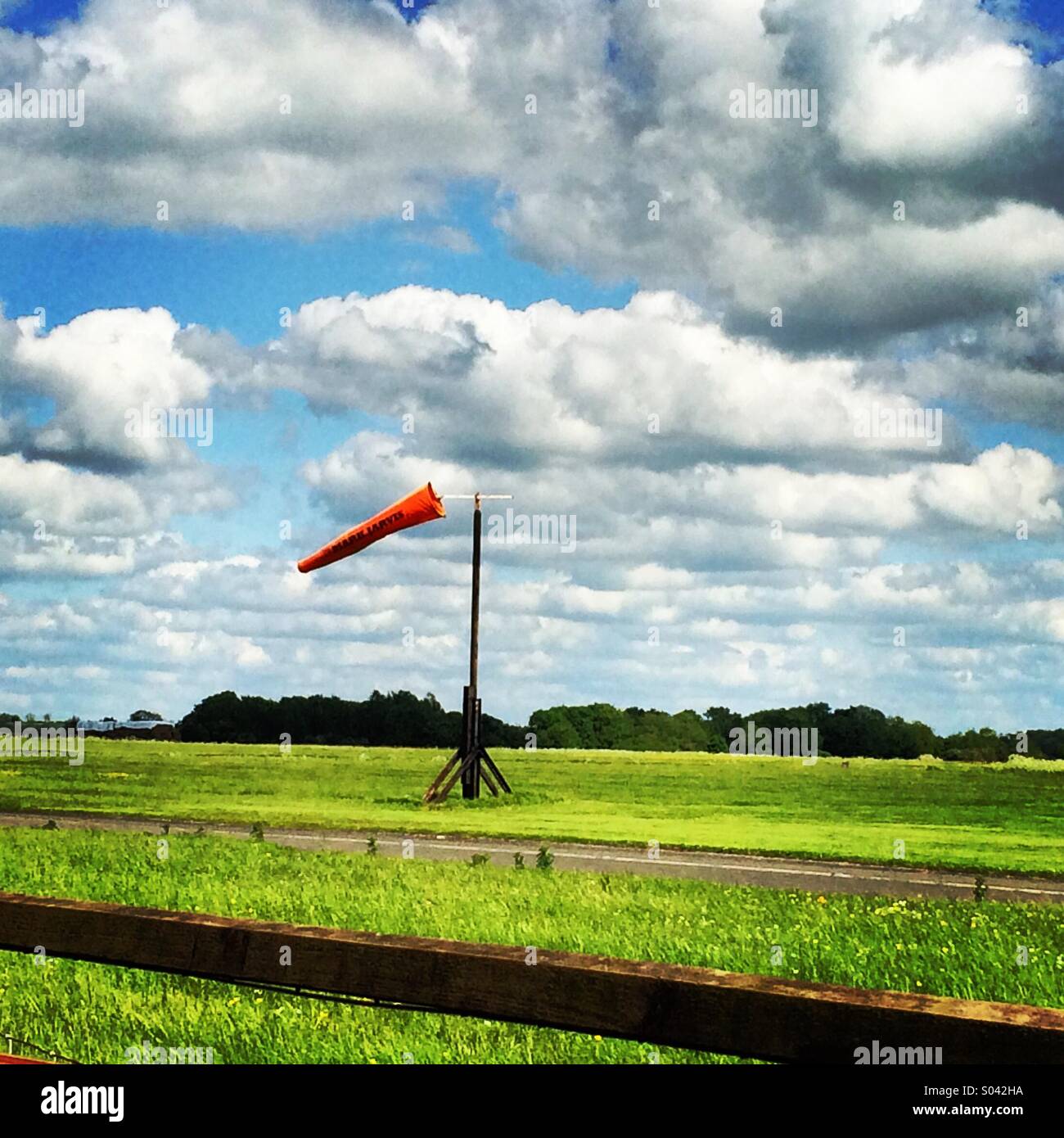 Windsack an einem windigen Tag auf eine kleine Flying Club Start-und Landebahn. - Smartphone-aufgenommenes Stockfoto