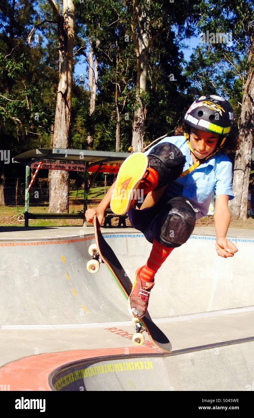 Boy in Nimbin Skatepark tun Trick in Schüssel Stockfoto