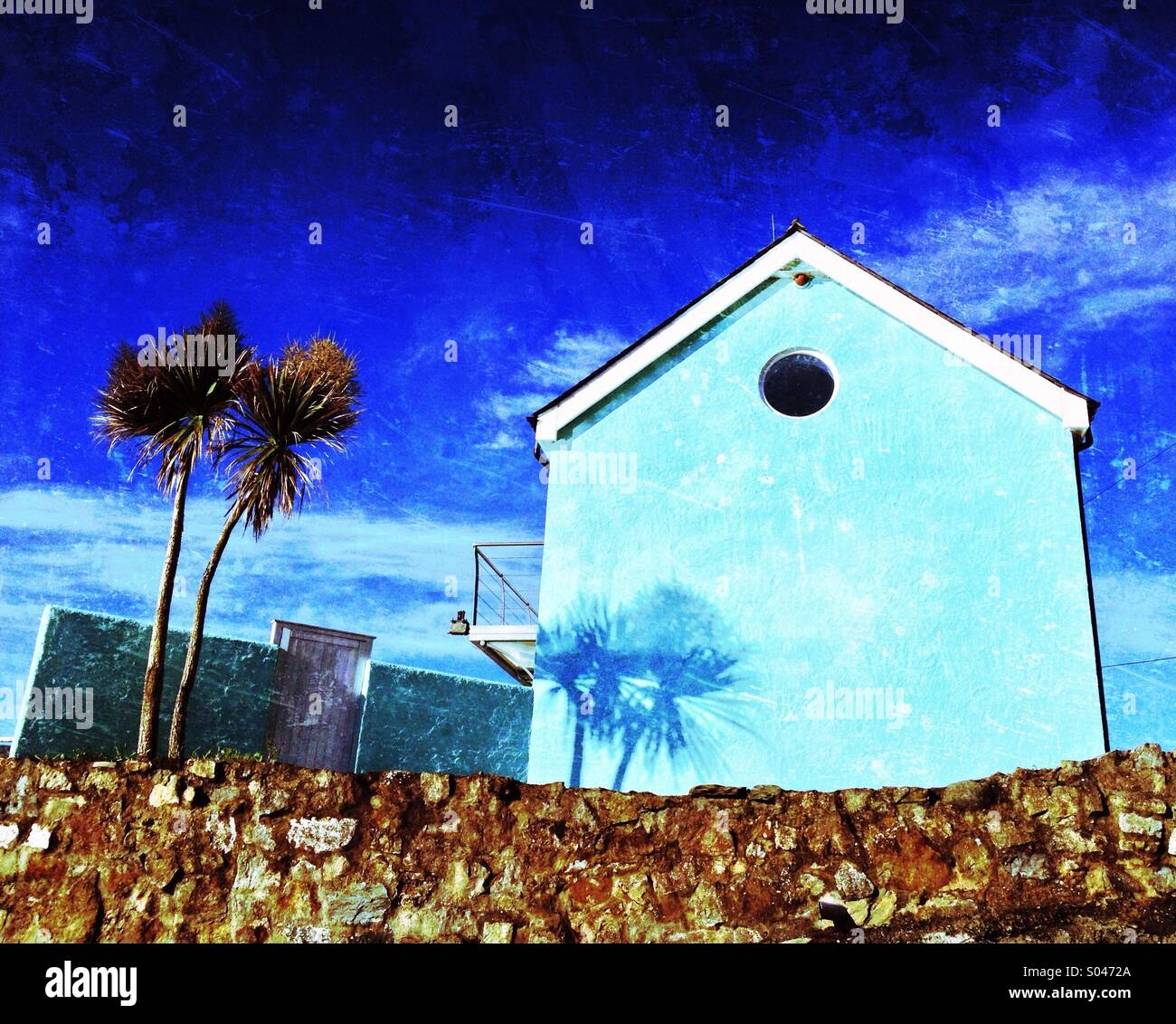 Blaues Haus und Palmen Bäume Stockfoto