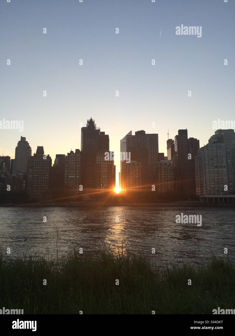 Fang die Sonne durch die Skyline von Manhattan, von Roosevelt Island. Stockfoto