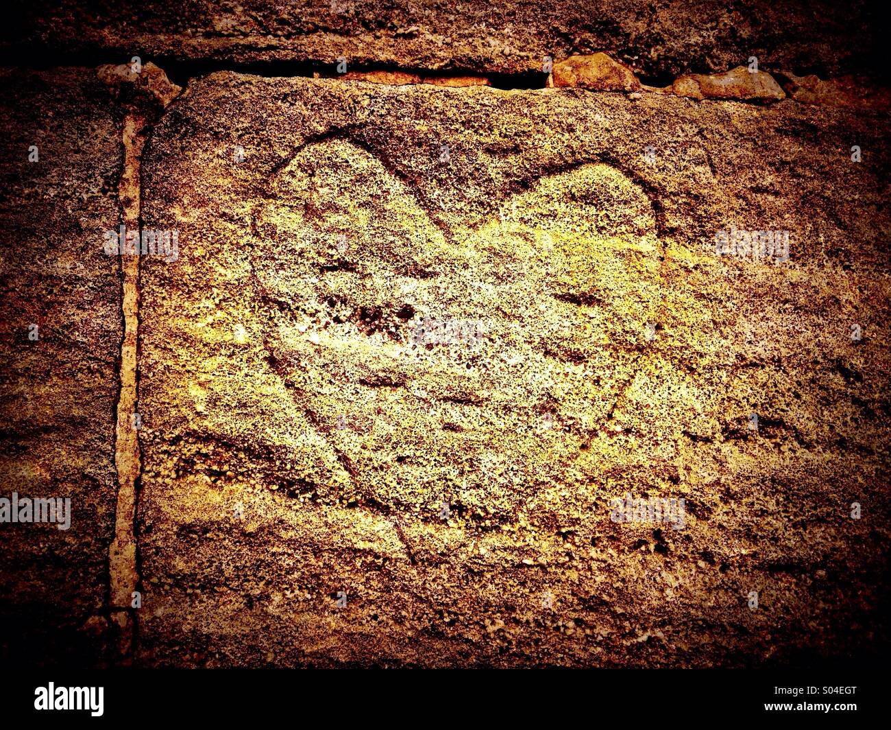 Herz in Stein Ziegel geschnitten - Smartphone-aufgenommenes Stockfoto
