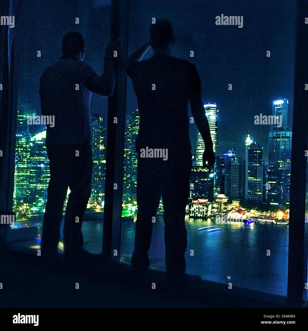 Nachtansicht von 2 Personen über Singapur Becken vom Marina Bay Sands Casinohotel Stockfoto