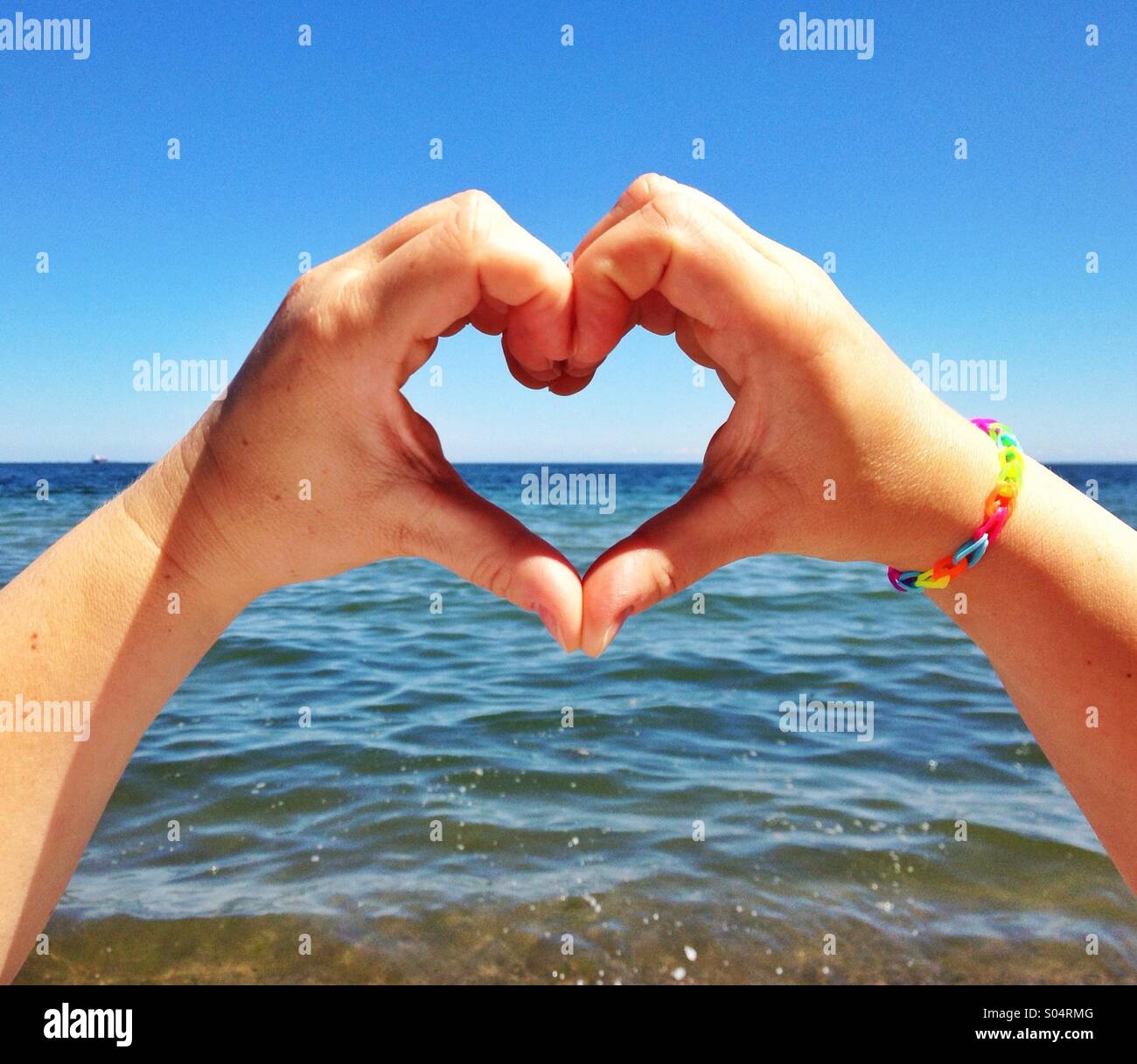 Händen Liebesherz gegen das Meer Stockfoto