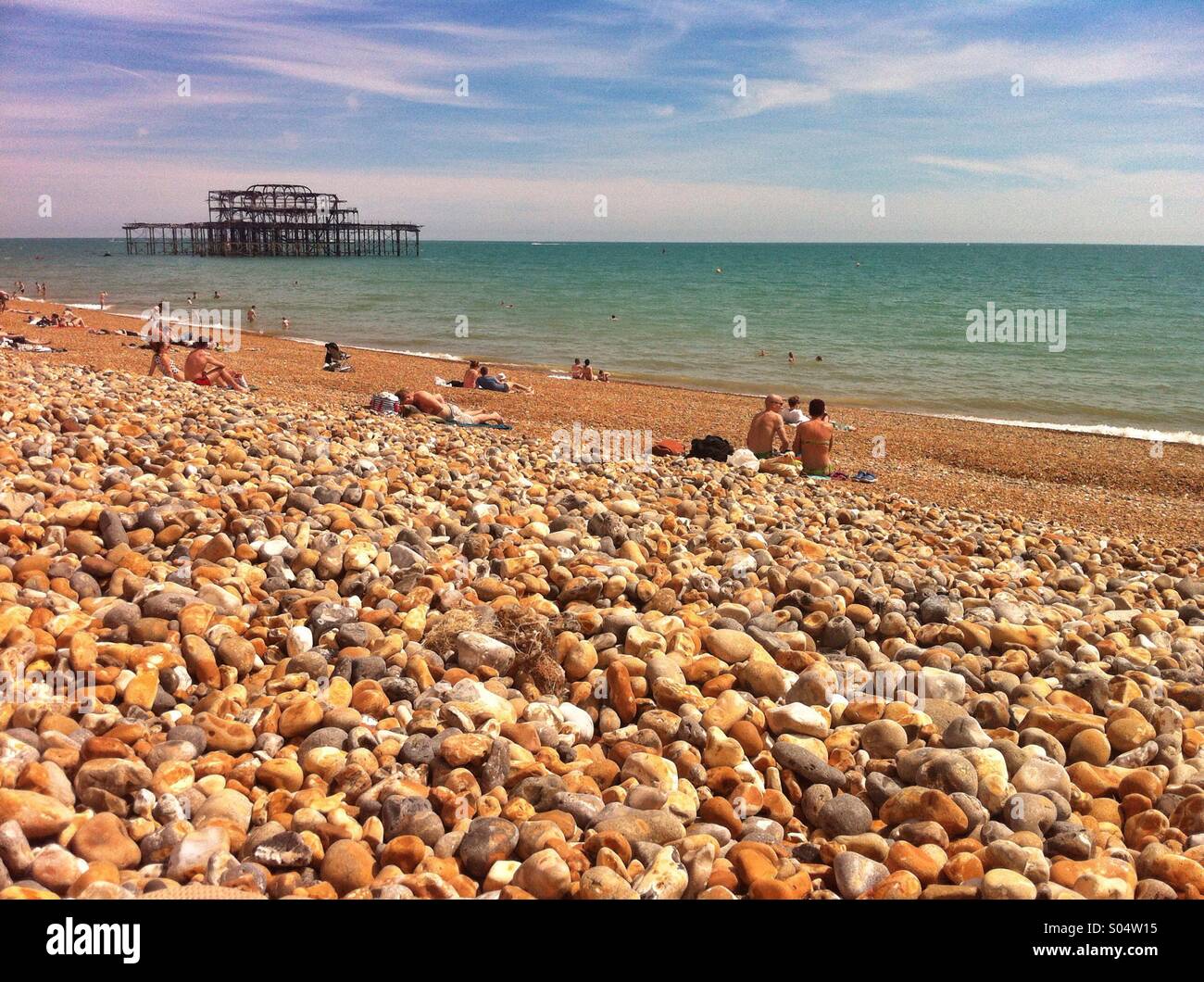 Sonnentag am Strand von Brighton, mit dem West Pier im Hintergrund. Brighton, England. Juni 2014. Stockfoto