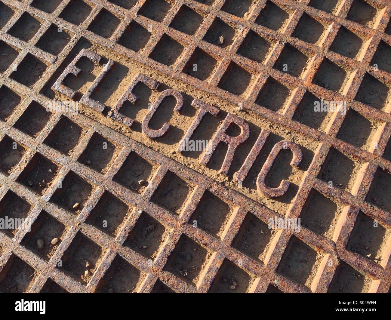 Alte rostige "elektrischen" Mann Loch Abdeckung. Stockfoto