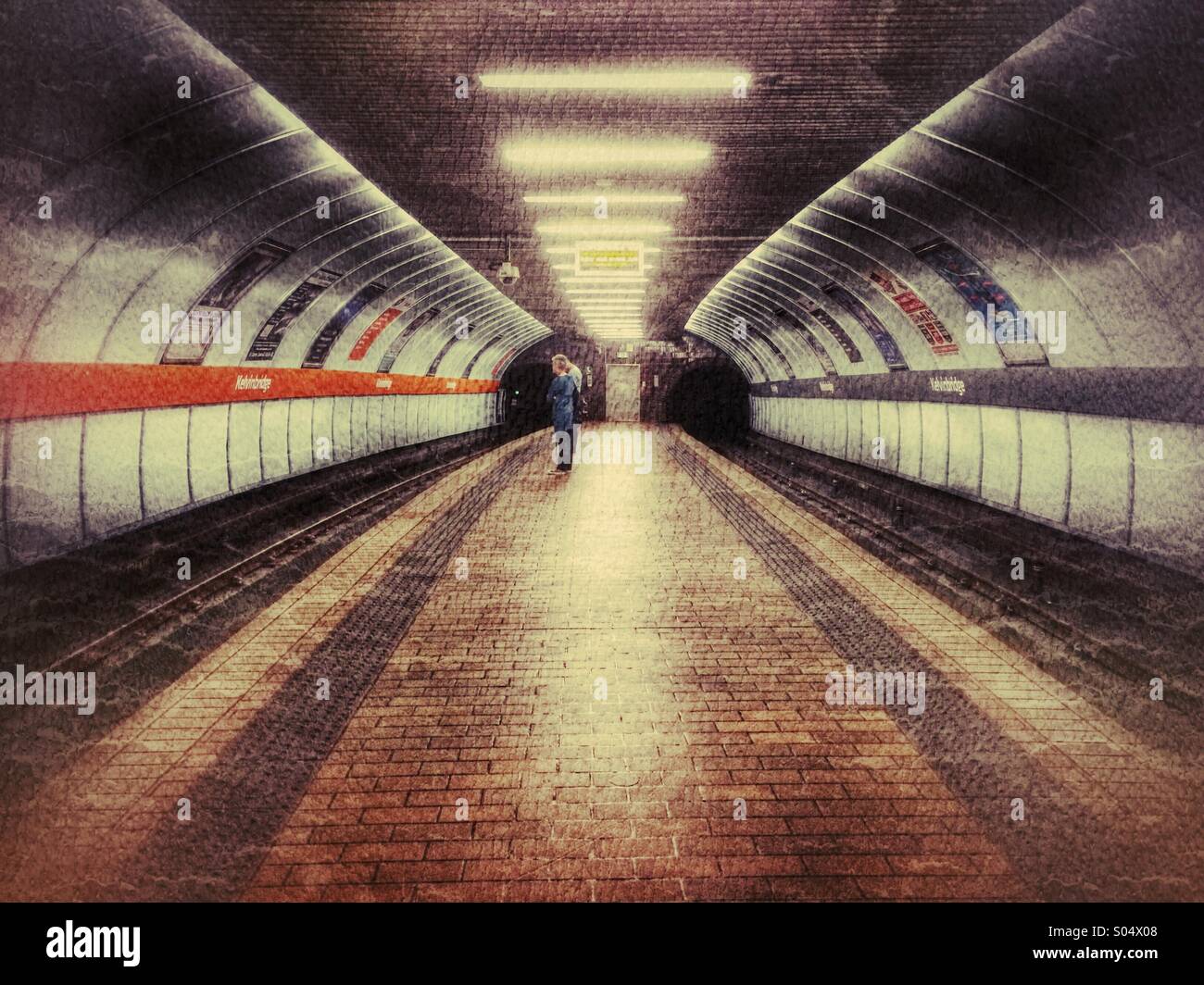 Ein Mann und eine Frau warten in einer u-Bahn in Glasgow, Schottland, Vereinigtes Königreich Stockfoto