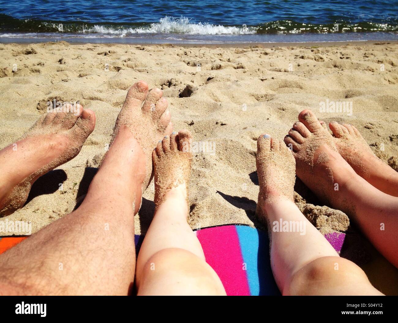 Beine der Familie am Strand zu entspannen Stockfoto