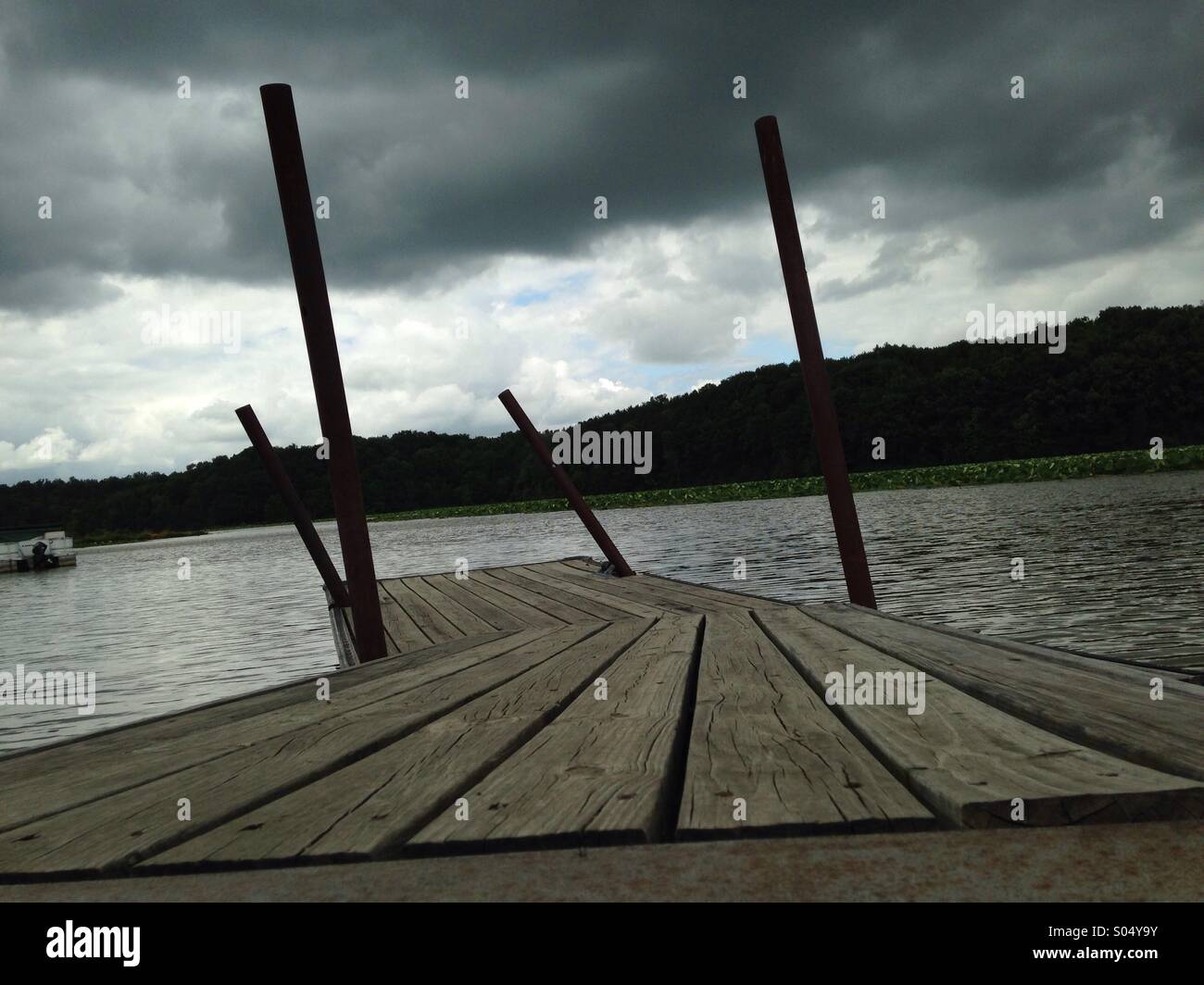 Einem krummen Pier mit dunklen bewölkten Himmel. - Smartphone-aufgenommenes Stockfoto