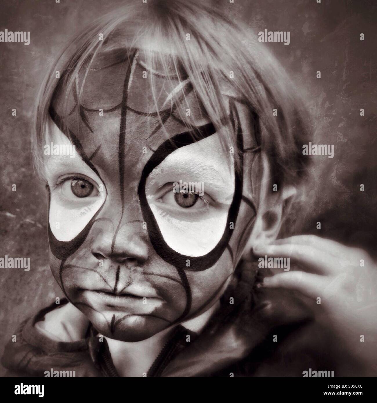 Traurig Spidey. Junge unglücklich in Spider-Man Gesicht Make-up Stockfoto