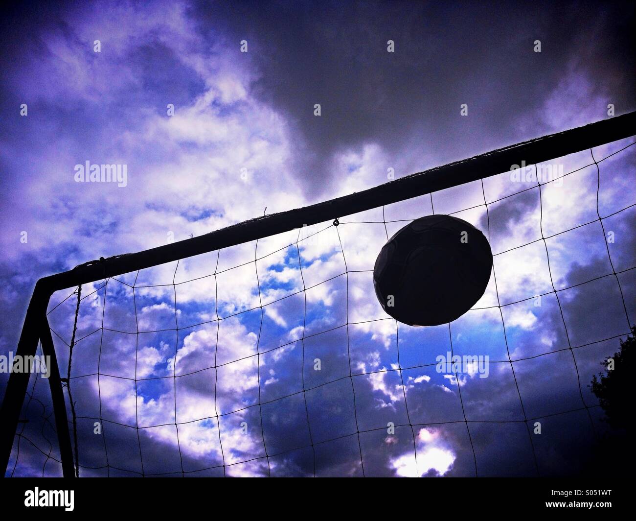 Fußball ins Tor gegen dramatischer Himmel fliegen Stockfoto