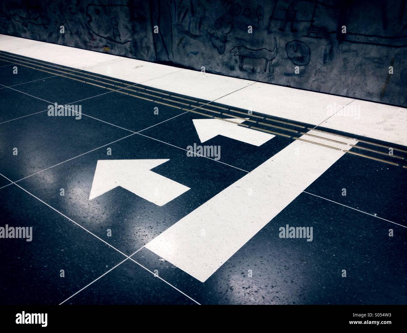 Richtungspfeile auf der Stockholmer u-Bahn-Bahnsteig Stockfoto