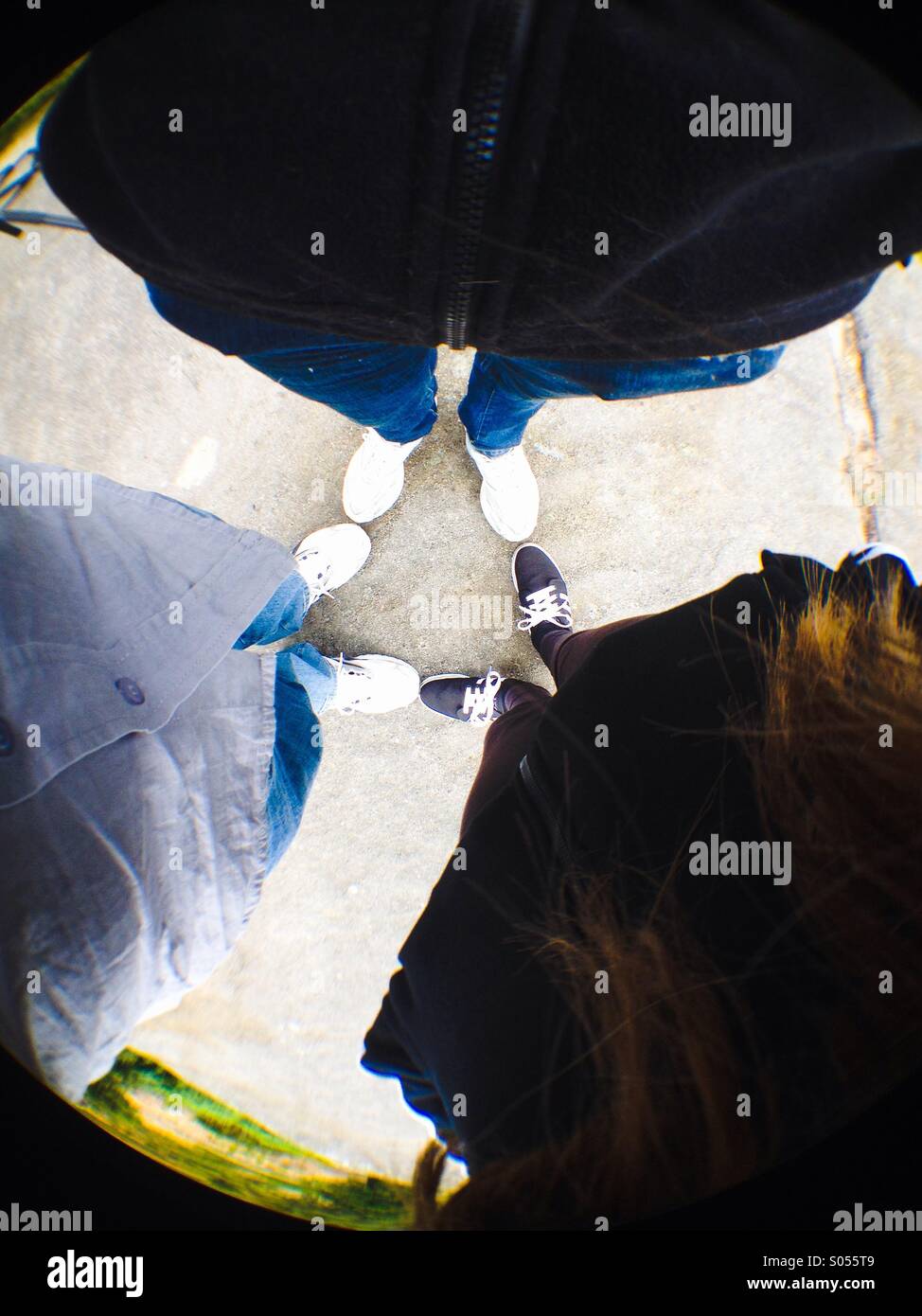 Ansicht von drei Menschen stehen in einem ring - Smartphone-aufgenommenes Stockfoto