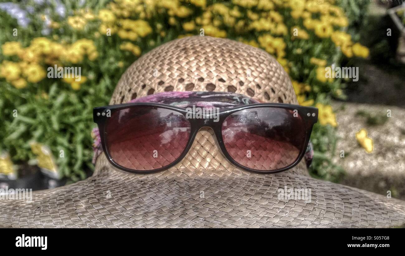 Sonnenbrille auf Strohhut Stockfoto