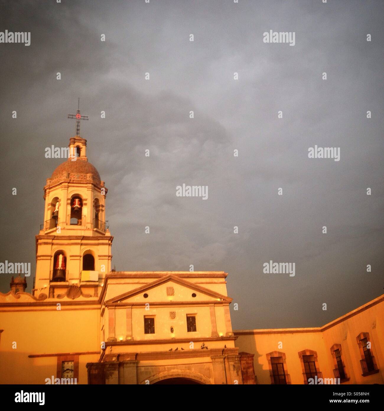 Die Kirche des Kreuzes in Queretaro, Mexiko bei Sonnenuntergang beleuchtet. Stockfoto