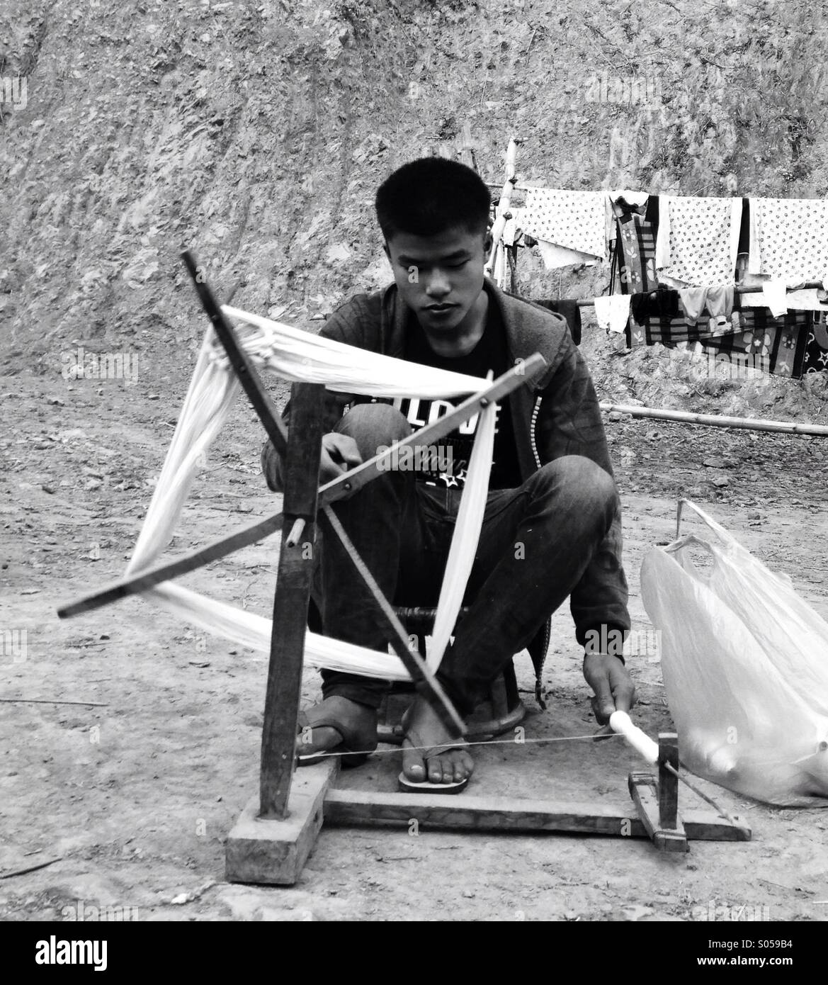 Tribal Mann und Spinnrad in Laos Stockfoto