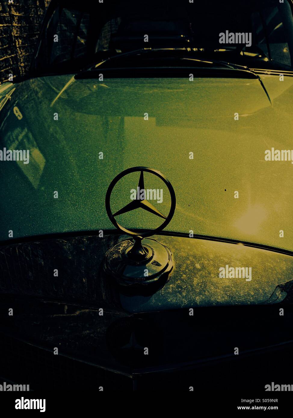 Stimmungsvolle Bild der klassischen Mercedes-Emblem mit Sonnenlicht auf Motorhaube - Smartphone-aufgenommenes Stockfoto