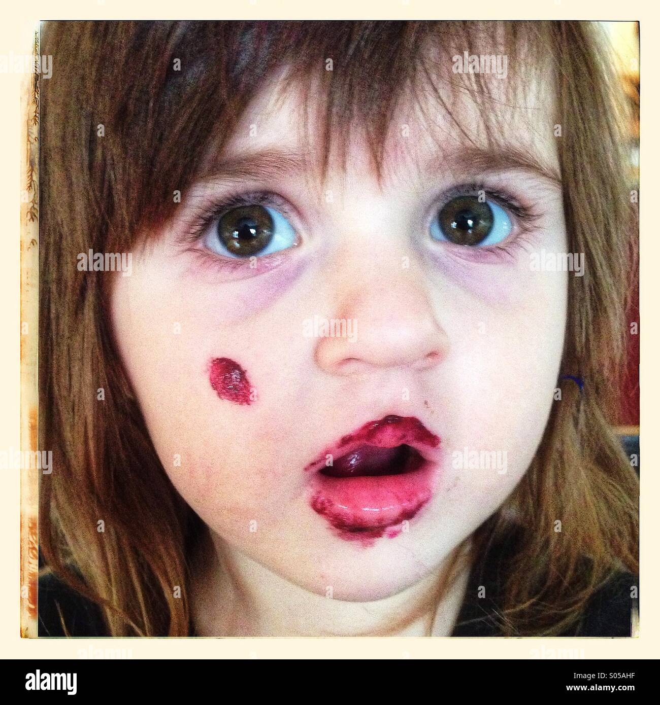 Kleines Mädchen mit Farbe im Gesicht Stockfoto