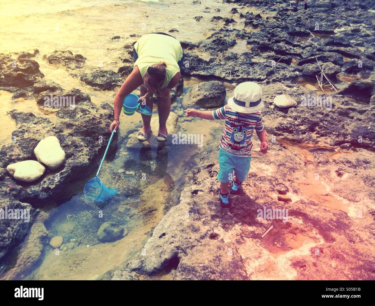 Mutter und Sohn suchen in den Fels-Pools am Strand, Javea, Spanien Stockfoto