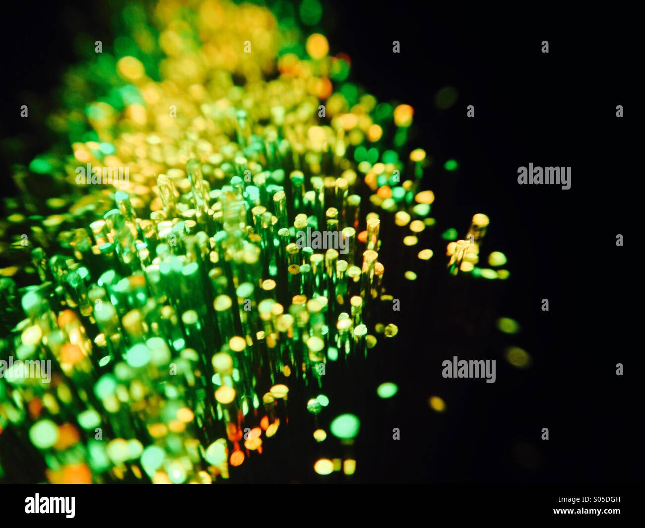 Glasfaser-Stränge emittierende grüne und orangefarbene Licht Stockfoto