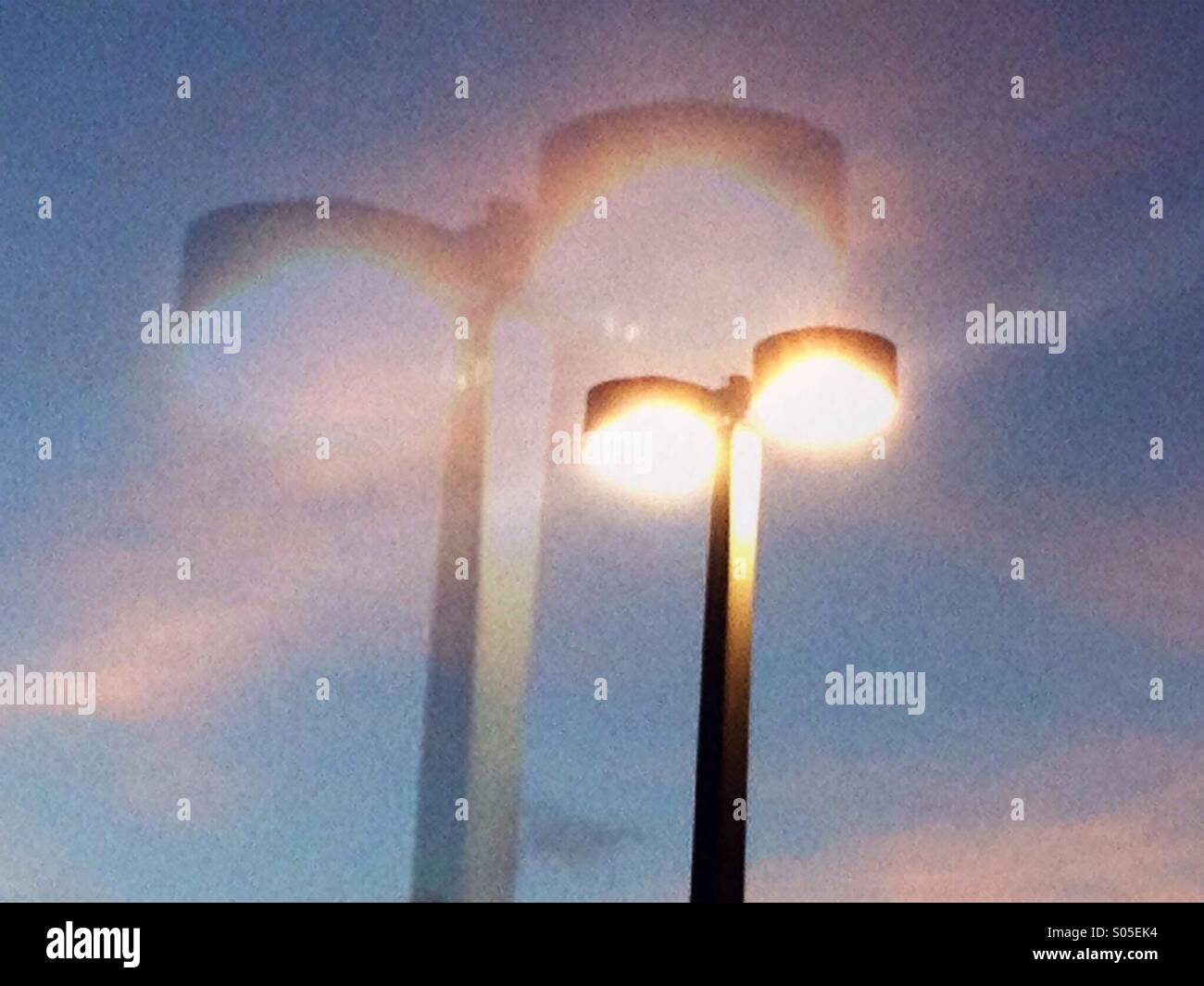 Doppelbelichtung Parkplatz Lichter in den späten Abend mit einem schönen rosa Himmel. Stockfoto