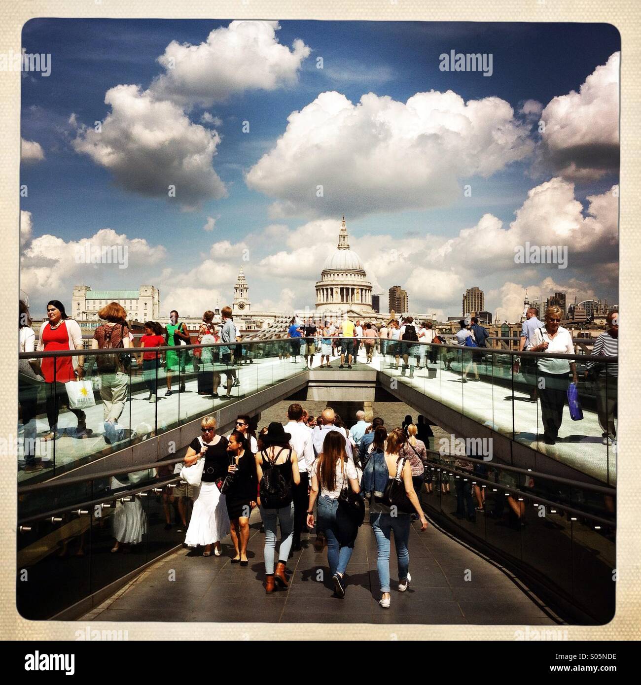 Die Menschen gehen auf die Millennium Bridge mit St. Pauls Kathedrale im Hintergrund. London England UK. - Smartphone-aufgenommenes Stockfoto