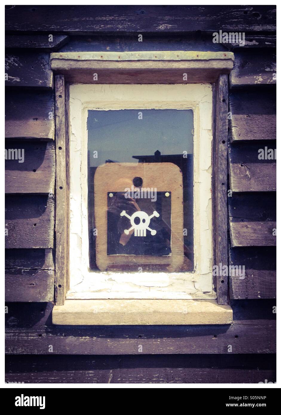 Schädel und gekreuzten Knochen im Fenster Stockfoto