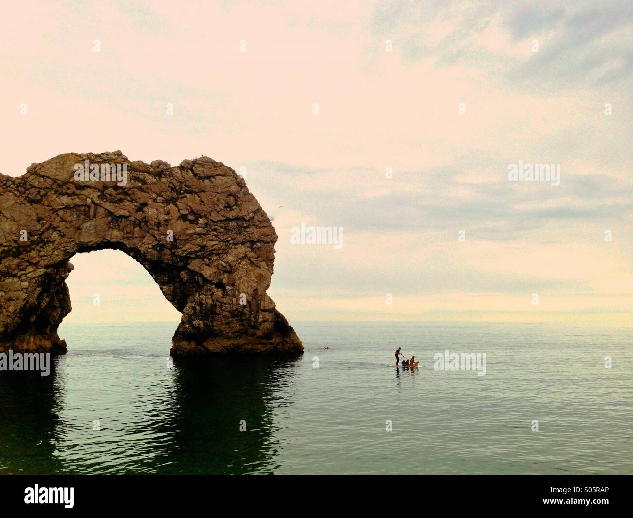 Eine Familie genießen Sie das Meer auf einem Paddle Board bei Durdle Door Strand, Lulworth Estate, West Dorset. Stockfoto