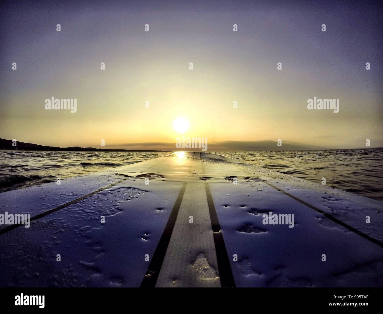 Board mit Sonnenuntergang Wasser Stockfoto