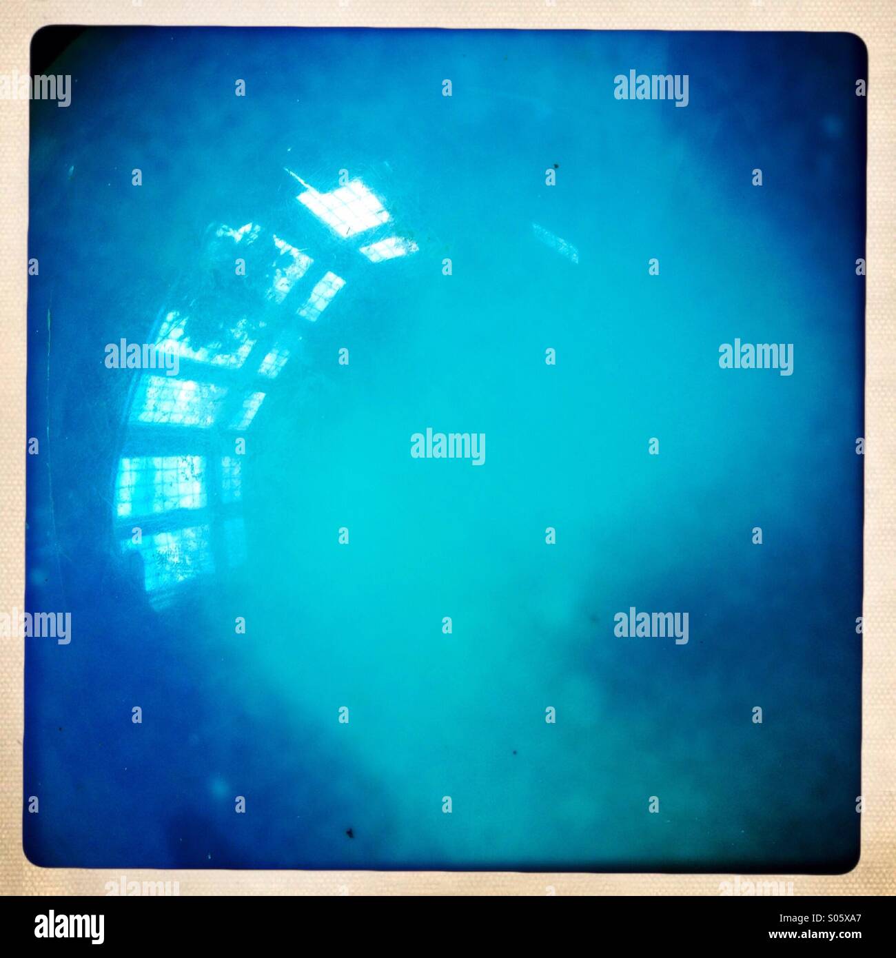 Nahaufnahme von einem blauen Ball mit einer Reflexion eines großen Fensters Stockfoto