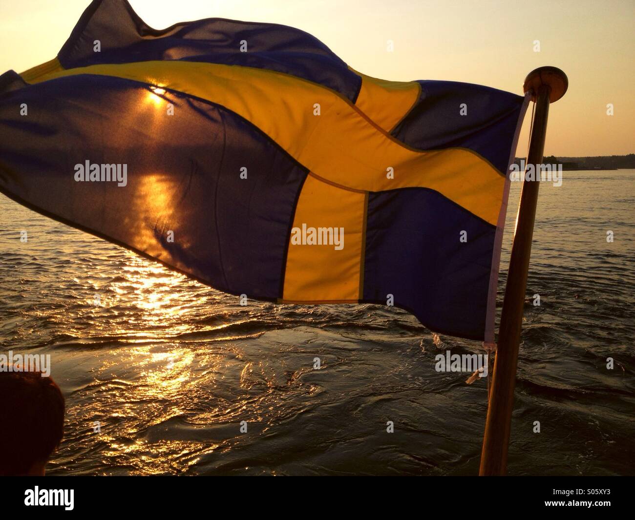 Schwedische Flagge am Boot bei Sonnenuntergang Stockfoto