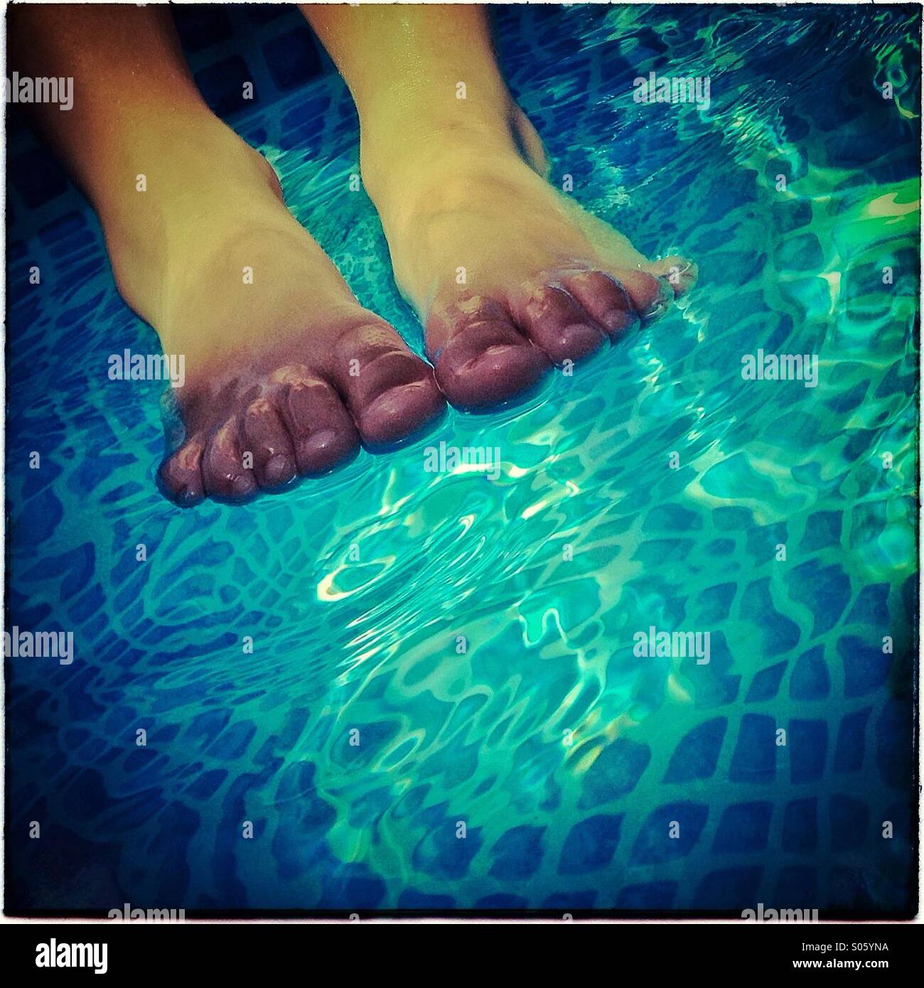 Füße auf pool Stockfoto