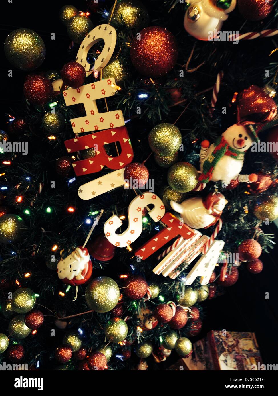 Weihnachten in Holzbuchstaben auf Weihnachtsbaum ausgeschrieben - Smartphone-aufgenommenes Stockfoto