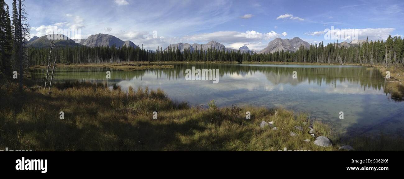 Panorama der Bergwelt spiegelt sich in einem ruhigen Teich in Kananaskis Country, Alberta, Kanada. Stockfoto