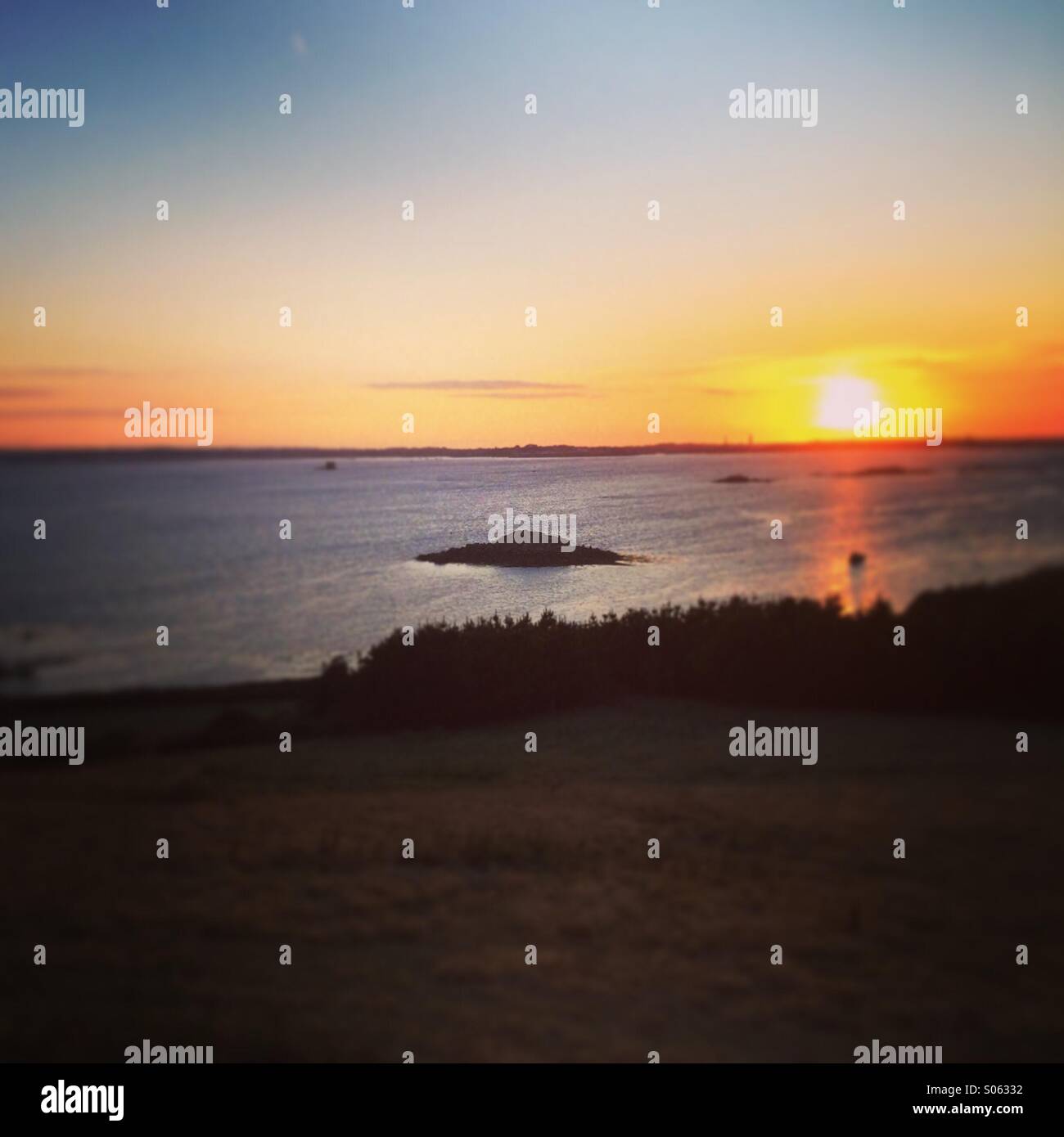 Sonnenuntergang hinter Guernsey gesehen von Herm Stockfoto